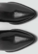 Bota de caña alta estilo cowboy confeccionada en piel bovina, con punta fina y tacón rectangular de 5 cm.