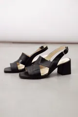 Sandalia de cuero vacuno color marrón, con taco ancho, diseño de tiras anchas cruzadas y tira con textura. Cuenta con tira ajustable al tobillo con hebilla metálica.