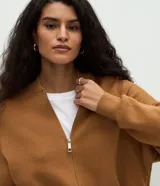 Campera de punto de corte regular y estilo oversized, confeccionada en una mezcla de viscosa, poliéster y poliamida. Presenta cierre frontal completo, mangas largas con puños acanalados y acabado acanalado en el ruedo.