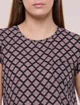 Blusa de gasa ligera con diseño geométrico en tonos oscuros, escote redondo, mangas cortas y bolsillo frontal aplicado. Presenta un ruedo redondeado y silueta relajada.