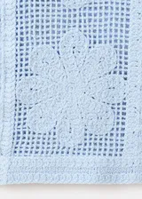 Pantalón tejido de punto celeste con diseño calado de flores, de corte recto y tiro medio con cintura elástica.