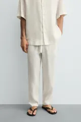 Pantalón relaxed fit de lino color negro, con cintura elástica ajustable con cordón y bolsillos frontales.
