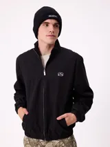 Campera Rusty de corte clásico, color negro, con cierre frontal completo, cuello alto y puños elásticos. Presenta un diseño minimalista con el logo de la marca bordado en el pecho.