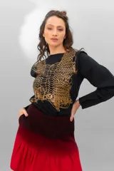 Remera negra de algodón con estampado dorado que simula un tejido o collar sobrepuesto. Presenta una moldería que realza los hombros y se entalla levemente hacia la cintura.