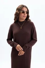 Vestido largo de tejido de punto color marrón oscuro, de manga larga y cuello alto.