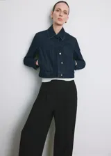 Pantalón de vestir negro de tiro medio y corte recto, con detalle de pinzas y bolsillos laterales.
