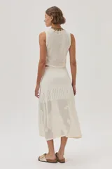 Top tejido de punto calado color crudo con diseño de flores, escote redondo y lurex en el escote.