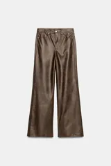 Pantalón de tiro medio confeccionado en tejido efecto piel, con diseño de cinco bolsillos y cierre frontal con cremallera y botón.