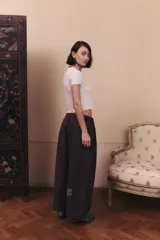 Pantalón de gabardina impermeable color marrón chocolate, con silueta amplia y relajada. Presenta cintura elastizada con pinzas delanteras que aportan volumen y movimiento a la prenda.