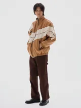 Campera de denim estilo deportivo con diseño de paneles en tonos azul claro y blanco, cuello alto, cierre frontal y bolsillos laterales con cierre. Presenta corte oversized con puños y cintura elásticos.
