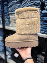 Botas negras de caña media con plataforma y detalle de piel sintética en la parte superior.