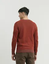 Sweater de punto con cuello redondo, manga larga y puños y ruedo acanalados. Presenta un diseño jaspeado en tonos oscuros.