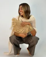 Clutch de rafia natural con flecos, cierre superior con cremallera y forro interior de tela.