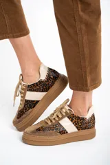 Zapatillas bajas de cuero color marrón con estampado animal print, cordones color beige y suela color caramelo.
