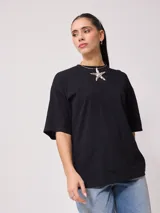 Remera negra de algodón con corte oversize y cuello redondo.