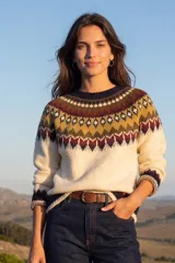 Buzo de tejido de punto con diseño de jacquard en la parte superior, cuello redondo y mangas largas. Presenta un patrón geométrico en tonos crema, mostaza, bordó y azul marino.