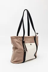 Bolso tipo tote de nylon negro con bolsillo frontal en color crema y asas largas en cinta gris. Cuenta con cierre superior y diseño funcional de gran capacidad.