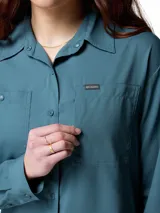 Camisa de senderismo Columbia Silver Ridge Utility de color azul, con protección solar y tecnología de absorción de sudor. Cuenta con mangas largas, bolsillos frontales con solapa y cierre de botones.