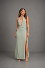 Vestido largo color verde agua, con escote halter profundo, espalda descubierta, detalle de nudo en la cintura y tajo lateral.