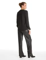 Blusa de gasa negra con diseño de doble capa, cuello a la base y escote en V pronunciado. Presenta mangas largas con puños anchos abotonados y un corte fluido.