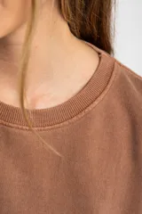 Buzo lila oversize confeccionado en 100% algodón, con cuello redondo, mangas largas y puños y dobladillo acanalados. Presenta un pequeño detalle bordado en el bajo.