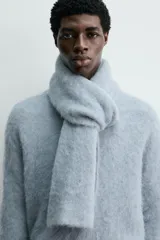 Bufanda de punto tejida en hilatura con mezcla de fibra de alpaca, de textura suave y diseño rectangular.