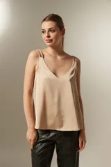Musculosa de satén color beige con escote en V y doble bretel fino.