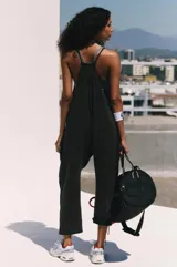 Enterizo de algodón y spandex color negro lavado, de corte holgado con entrepierna caída y tirantes finos. Presenta bolsillos laterales amplios.