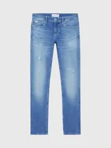 Pantalón de jean celeste con roturas en las rodillas, corte slim, tiro bajo y cinco bolsillos.