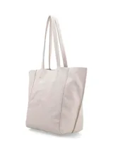 Cartera tipo shopper color crudo, confeccionada en cuero, de diseño amplio y sin forro con terminaciones al corte. Cuenta con doble asa de hombro y bolsillo interior con cierre.