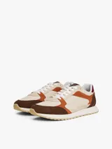 Zapatillas Tommy Hilfiger de estilo retro con paneles de ante y tela en tonos beige, marrón y naranja. Presentan suela gruesa dentada de goma, cierre con cordones y detalles de la marca en la lengüeta y el talón.