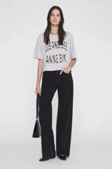 Remera gris melange de algodón con calce oversize, cuello redondo, mangas cortas y estampa frontal en contraste con texto negro.