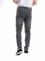 Pantalón de jean corte slim fit, color azul clásico, con cierre de botones y bolsillos laterales y traseros.
