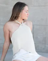 Top halter de cuero sintético color blanco, con espalda descubierta y tiras regulables en cuello y espalda.