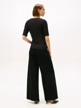 Remera negra de corte slim confeccionada en viscosa sostenible con elastano, con tejido de canalé 5x2. Presenta cuello redondo y mangas 3/4, con un diseño ajustado al cuerpo.