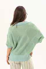 Buzo de punto color verde menta, con cuello polo y escote en V, mangas cortas y diseño holgado.