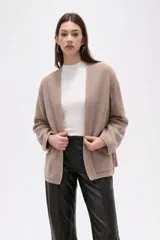 Saco abierto de tejido de punto con textura acanalada, mangas largas holgadas y bolsillos frontales aplicados.