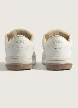 Championes Vans Hylane Vintage, color blanco con suela de goma marrón, diseño robusto de inspiración retro con la icónica franja lateral y cordones anchos.