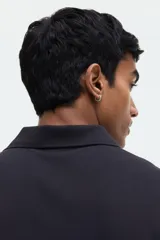Remera polo de manga corta en piqué de algodón color negro, con cuello clásico y tapeta de dos botones. Corte estándar para una silueta clásica y cómoda.