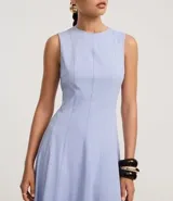 Vestido midi evasé de la marca Cortelle, confeccionado en bengalina de algodón con elastano. Presenta cuello redondo, diseño sin mangas con breteles anchos y cierre trasero mediante cremallera.