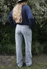 Jean de tiro alto con corte straight flare, confeccionado en denim de algodón con estampado geométrico de rombos y motivos florales en tonos azulados.