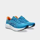 Championes de running Asics Versablast 4, color negro con detalles en naranja y suela blanca con tecnología AmpliFoam+. Diseño ligero y reactivo para entrenamiento versátil.