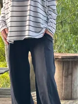 Remerón de manga larga, color blanco con rayas horizontales negras, corte oversize con tajos laterales y bajo redondeado.