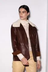 Chaqueta estilo blazer color marrón con flecos en la parte delantera y trasera, solapas y bolsillos frontales.