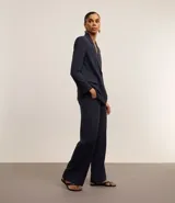 Pantalón de vestir azul marino, de corte wide leg, con cintura alta, pliegues frontales, bolsillos laterales y aplicación de strass.