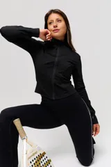 Campera deportiva negra de corte crop, con cierre frontal completo y cuello alto. Confeccionada en tejido técnico elástico, presenta costuras reforzadas que realzan la silueta.