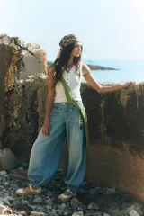 Musculosa blanca de algodón acanalado con escote henley abotonado y costuras visibles en los bordes.