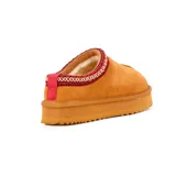Pantufla de cuero gamuzado color camel con plataforma dentada y detalle de cinta tejida decorativa en el borde superior.