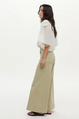 Jean estilo wide leg de tiro alto y pierna ancha, color verde claro, con costuras frontales marcadas y bolsillos laterales.