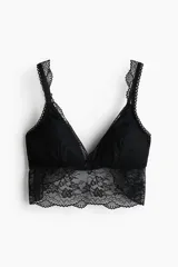 Bralette negro de encaje con relleno extraíble, breteles ajustables y una banda ancha de encaje en el bajo. Cuenta con un pequeño lazo decorativo en el centro.